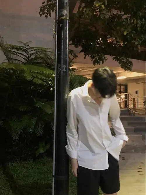 38 Cậu bạn mặc áo đen có cổ đứng dưới ánh sáng xanh, để khẩu trang sáng che mặt rồi xoay lệch người, ánh nhìn hắt ngang khiến khung hình đẹp và lạnh, hợp kiểu ảnh selfie nam lạnh lùng rất rõ chất