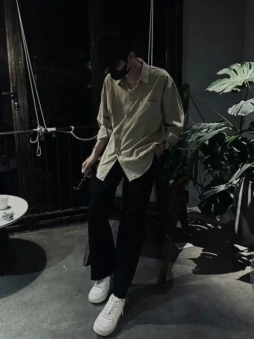 39 Ảnh chàng trai ngồi ở góc quán, tóc phủ dày xuống trán và mũi khi đầu gập thấp, hai tay đặt hờ trên đùi tạo thế khép, bức hình hấp dẫn theo kiểu âm thầm chứ không cần phô gương mặt