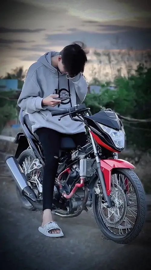 6 Chàng trai ngồi trên xe đạp nhỏ ở nền chiều xám, gập người xuống để mái tóc rủ kín mặt, tay ôm lấy đầu gối tạo dáng khép, mang cảm giác cô độc nhưng quyến rũ theo kiểu ảnh chân dung tối màu