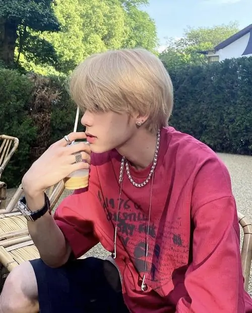 10 Mái tóc vàng sáng và áo đỏ hồng làm cậu trai nổi bật giữa nền cây núi phía sau tư thế ngồi nghiêng bên lan can tạo cảm giác phóng khoáng bức hình nghiêng về ảnh chân dung nam có khí chất riêng khá rõ