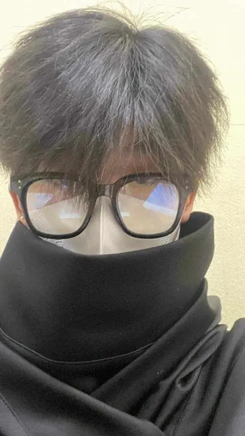 11 Góc chụp chàng trai quấn khăn đen kín cổ chỉ để lộ đôi mắt sau gọng kính tròn tạo vẻ bí ẩn mạnh và lạnh mái tóc xám bạc giúp khung hình có điểm nhấn nam tính mà không cần nhiều chi tiết