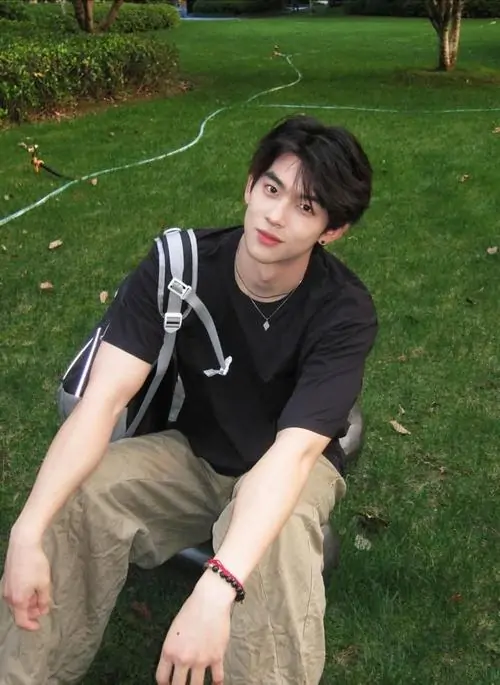 18 Bãi cỏ xanh làm nền cho cậu trai mặc áo đen ngồi duỗi tay chân thoải mái vẻ nhìn thẳng máy đem lại cảm giác gần mà vẫn mạnh đây là kiểu ảnh idol nam rất hợp gu người thích phong vị nam tính