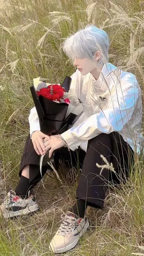 1 Ảnh trai đẹp với mái tóc sáng nổi bật giữa bãi cỏ khô khi chàng ngồi cạnh chú chó đen ôm bó hồng đỏ nhỏ tạo cảm giác dịu mà vẫn mạnh mẽ gương mặt sáng sủa và khung hình rất có chất