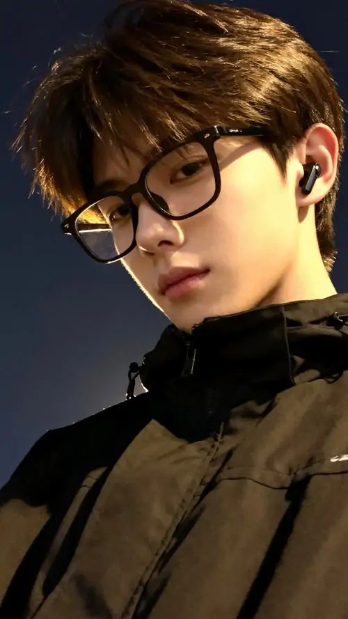 27 Ảnh trai đẹp chụp studio với kính gọng đậm và áo cổ cao đen làm gương mặt nổi khối rõ dưới ánh sáng gắt mái tóc nâu vuốt nhẹ giúp tổng thể giống tinh thần Vương Nhất Bác ở vẻ sắc mà vẫn trầm