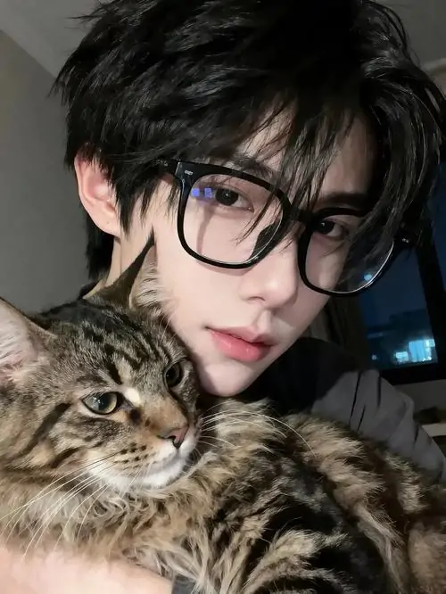 11 Chân dung chụp gần với mèo mướp nằm trong tay, chàng trai đeo gọng đen bản vừa, nhìn thẳng đầy tập trung, sự kết hợp giữa thần thái lạnh lùng và thú cưng mềm mại làm ảnh nam thần đeo kính trở nên có chiều sâu hơn