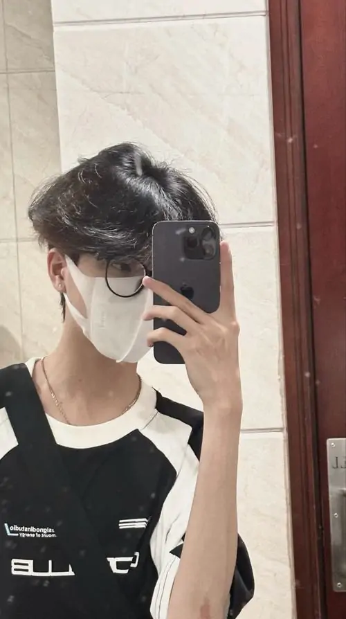 22 Gương selfie trong phòng với chàng trai mặc áo đen và đeo khẩu trang, tay cầm điện thoại che gần hết mặt, kiểu gọng kính mảnh làm bức ảnh gọn hơn, tạo chất phố xá trẻ trung và hơi nổi loạn mà không bị nặng nề