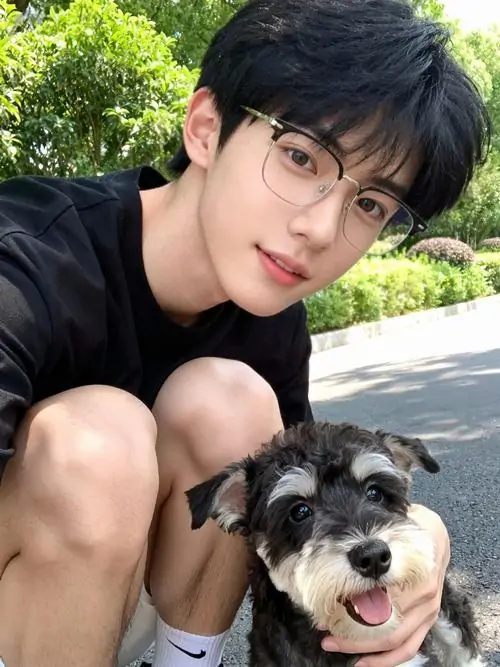 7 Ảnh soái ca đeo kính ghi lại khoảnh khắc chàng trai ngồi gần chú chó ngoài trời, áo đen giản dị và nụ cười nhẹ làm khung hình bớt lạnh, bối cảnh xanh mát đem lại sức hút gần gũi, đúng chất ảnh chân dung nam dễ mến