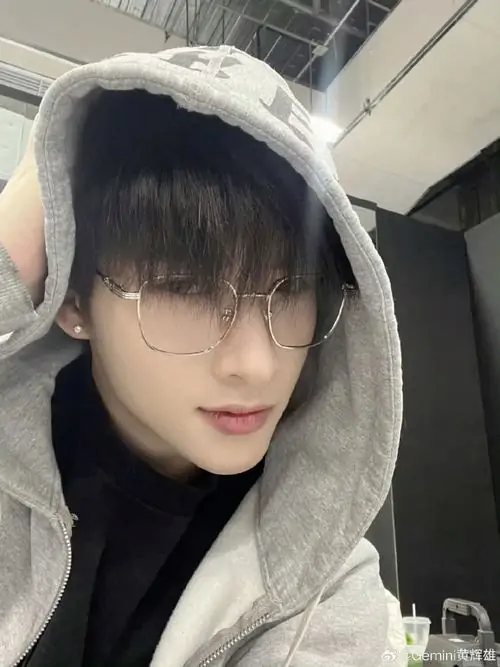 37 Ảnh nam thần đeo kính trong căn bếp sáng, chàng trai buộc tạp dề và quay đầu cười khi đang pha cà phê, chi tiết đời thường khiến khung hình mềm hơn, đồng thời làm ngoại hình trở nên gần gũi và đáng mến