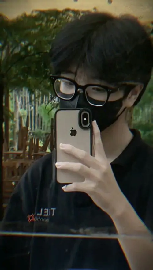 49 Chàng trai dựa tường gạch cũ, tay đút túi và đầu hơi cúi, kính gọng kim loại phản sáng nhẹ tạo điểm nhấn, bức ảnh nam lạnh lùng mang chất đường phố nhưng vẫn giữ được vẻ tự nhiên và không quá phô trương