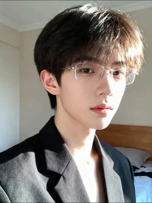 30 Chàng trai ngồi trong quán cà phê sáng sớm, tay giữ cốc nóng và mắt nhìn xuống trang sách, kính gọng tròn làm tổng thể mềm hơn, bức ảnh mang vẻ tri thức nhưng không khô khan, rất hợp người thích không khí yên tĩnh