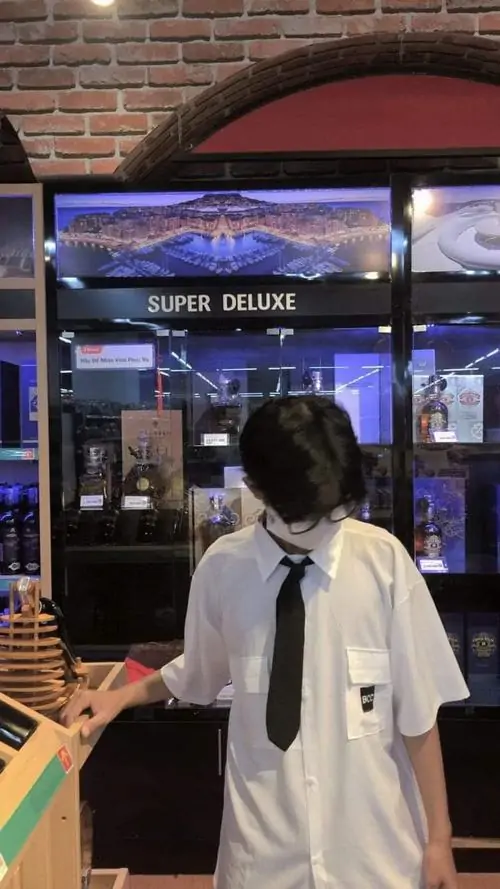 10 Cậu trai hot boy K10 mặc áo trắng với outfit đơn giản trend Gen Alpha nụ cười tươi background nội thất ấm áp tạo cảm giác trẻ trung năng động.