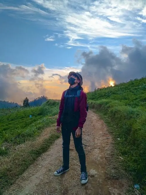 17 Gương mặt boy Gen Alpha Chàng trai ngồi ghế mây với nụ cười tươi dáng người cao ráo outfit xanh background ngoài trời mang phong cách đời thường cute.