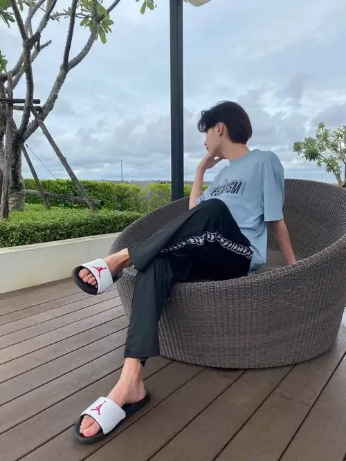 18 Cậu trai nhảy trên đường với tay dang rộng outfit trắng đen gương mặt góc cạnh background đường nhựa toát lên năng động cho Gen Alpha điển trai.