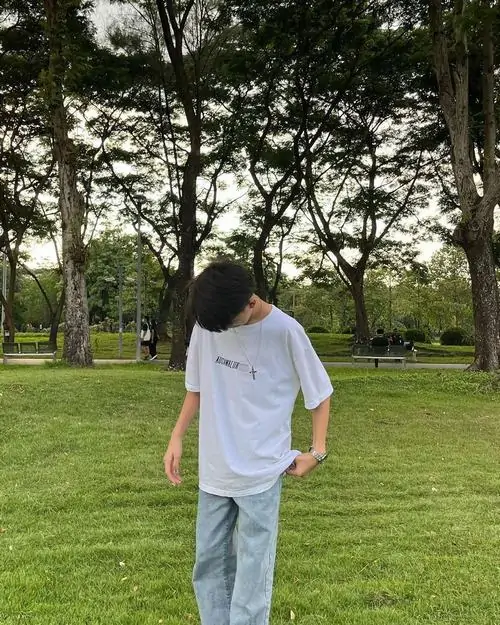 2 Cậu trai hot boy K10 đang đứng trên bãi cỏ với biểu cảm ngại ngùng tóc tai gọn gàng outfit trắng background khu vườn xanh khiến bức ảnh toát lên sự thuần khiết dễ thương.