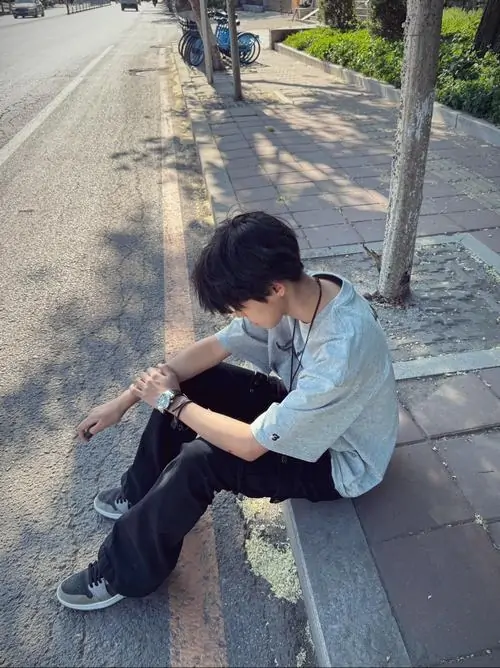 7 Gương mặt boy Gen Alpha Thiếu niên ngồi trong nhà với nụ cười hồn nhiên gương mặt baby face tay giấu mặt nhẹ outfit trắng filter trẻ trung làm bức ảnh đẹp mắt.