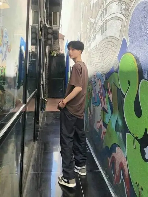 22 Một hot boy học đường đứng giữa công viên nắng nhẹ, áo rộng màu đen và kính đỏ khiến tổng thể có điểm nhấn riêng, dáng người thẳng và nền cây xanh giúp bức ảnh mang vẻ cuốn hút theo kiểu rất tự nhiên