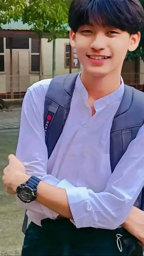 23 Hình nam sinh 2k8 ghi lại khoảnh khắc đứng sát tường gạch với trang phục tối giản, tay buông nhẹ và mắt nhìn lệch sang bên, bố cục dọc làm sống mũi rõ hơn, hợp gu ảnh trai xinh học sinh thích vẻ gọn ghẽ