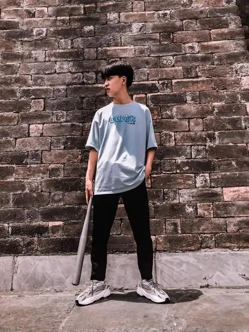 3 Hình nam sinh 2k8 chụp trước bức tường gạch cũ, áo phông sáng và quần đen giữ tổng thể gọn gàng, cách đứng nghiêng nhẹ tôn vóc dáng gọn gàng, hợp gu ảnh trai đẹp 2k8 thiên về sự đơn giản dễ nhìn