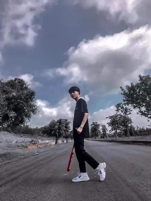 33 Khoảnh khắc chàng trai k8 ngồi trên bậc đá ở công trình cổ, tay chống nhẹ và chân đặt thoải mái, bối cảnh lớn phía sau làm nhân vật trông nhỏ nhưng có điểm nhấn, gợi đúng tinh thần ảnh du lịch tuổi học trò