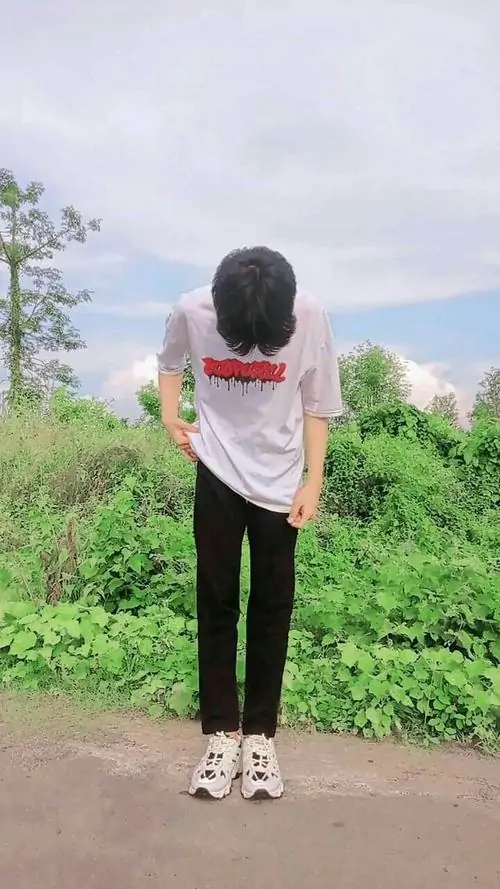 9 Ảnh boy phố k8 chụp từ sau lưng giữa bãi cỏ xanh, áo trắng nổi trên nền trời nhạt và dáng đứng khép chân tạo cảm giác lặng, khung hình thiên về tự nhiên, hợp nhóm ảnh trai đẹp che mặt theo kiểu kín đáo