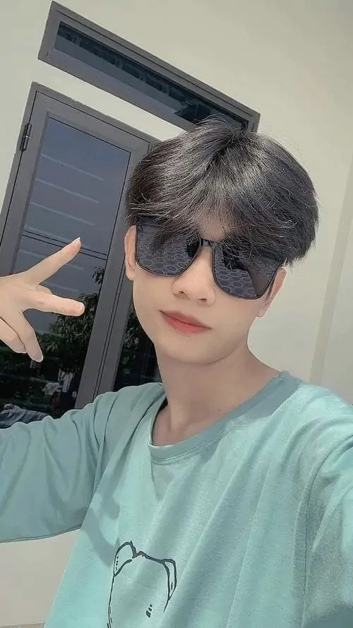 13 Hình hot boy 2k9 đeo kính giơ tay peace sign với áo xanh sunglasses giữa trời xanh thể hiện trổ mã tuổi teen cùng phong cách hiện đại của nam sinh lớp 10.