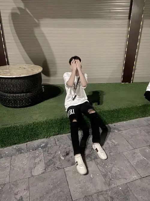 22 Cực phẩm 2k9 việt nam ngồi trên ghế đá công viên với áo khoác varsity và giày sneaker jordan toát lên thần thái cool ngầu cùng gu thời trang kết hợp đồng phục trường với đồ phố.