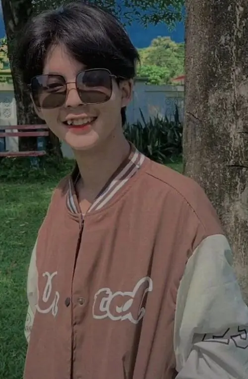 26 Chàng trai 2009 đứng bên ban công với balo sau lưng thể hiện áo khoác varsity và chiều cao bứt phá mạnh của boy phố thời trang đang độ trổ mã.