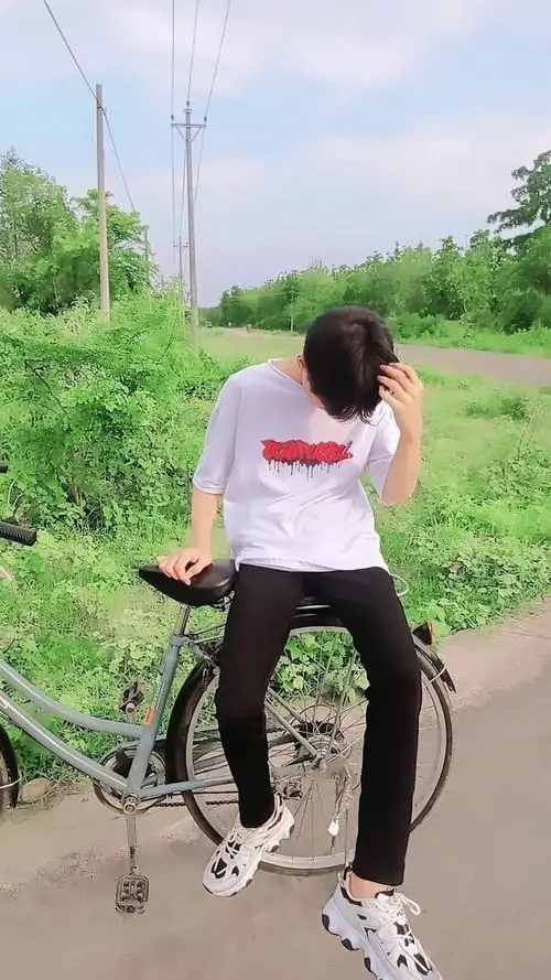 2 Chàng trai cưỡi xe đạp che mặt trong công viên với áo trắng in chữ quần đen sneakers trắng thể hiện hot boy 2k9 đẹp trai đầy năng lượng và gu thời trang đường phố.