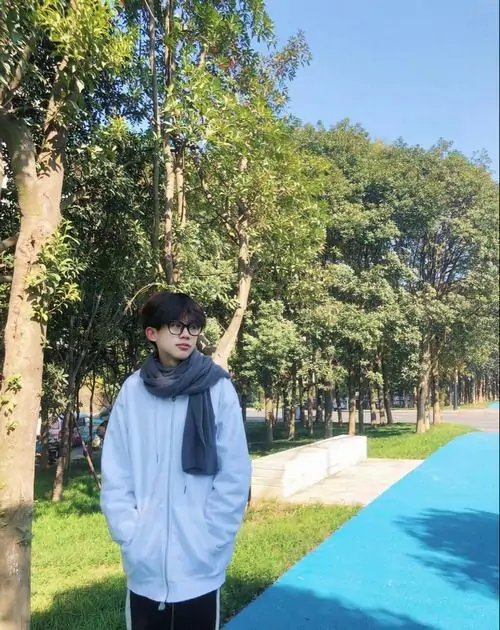 3 Hình hot boy 2k9 đứng giữa rừng cây với áo hoodie trắng quàng khăn choàng toát lên thần thái cuốn hút cùng khí chất học đường ấm áp của nam sinh lớp 10.