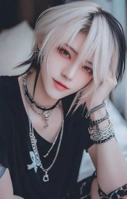 22 Cậu trai tóc sáng gần trắng mặc áo đen cùng vòng cổ nhiều lớp, tay chạm má và mắt nhìn thẳng, khung hình có độ tương phản cao, vừa nổi bật vừa lạ mắt, hợp kiểu con trai cá tính chuộng diện mạo khác biệt