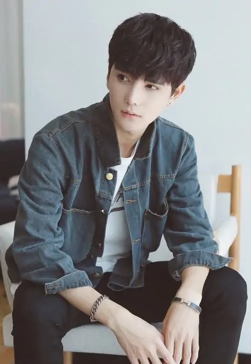 54 Cậu trai mặc sơ mi be ngồi cạnh bàn gỗ bên ly cà phê đen giữa không gian tối giản không cần tạo dáng nhiều vẫn hút mắt nhờ bố cục gọn và bờ hàm chắc đây là kiểu ảnh profile nam xem lâu không chán