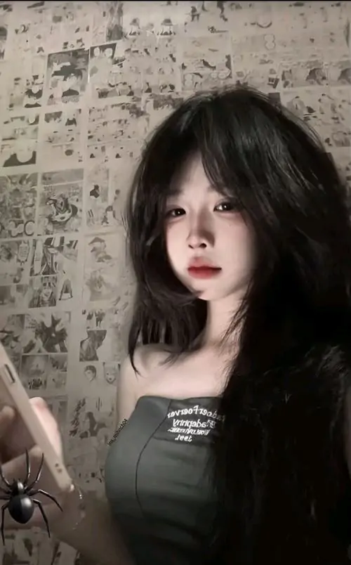 35 Cô gái tóc đen dày trong áo quây tối đứng trước nền tường xám loang, ánh nhìn chính diện làm ảnh gái xinh trở nên sắc nét hơn, vẻ đẹp cá tính hiện ra rõ qua đôi mắt sâu và thần thái hơi lạnh