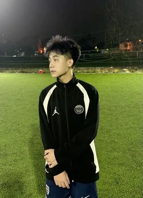 17 Bức ảnh nam sinh với áo khoác đen sọc trắng đứng trên sân cỏ đêm khoe chiều cao nổi bật và biểu cảm cool ngầu. Thiếu niên nam cao ráo Việt trong vibe học đường hiện đại toát lên sự chững chạc ban đầu của lứa tuổi mới lớn.