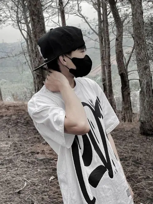 5 Bức ảnh hoodie boy Việt nhưng thực chất là áo thun trắng in chữ lớn kết hợp phong cách giấu mặt khi đứng giữa rừng cây. Thiếu niên nam trong sự chuyển mình nam tính nhẹ chạm tay vào cổ toát lên dáng vẻ khỏe khoắn của hot boy 2k11.