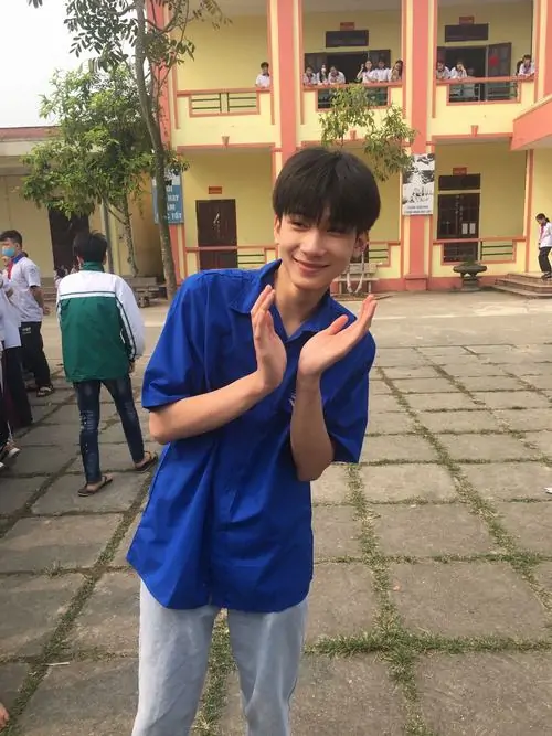 3 Chân dung hotboy với chiều cao nổi bật và năng lượng thể thao trong đồng phục polo xanh đang chắp tay giữa sân trường. Cậu chàng khoe nét nam tính nhẹ và chiều cao cao lớn dẫn đến dáng vẻ nam tính hơn.