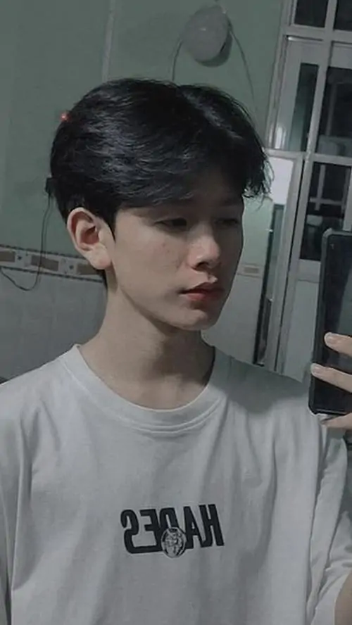 38 Thiếu niên nam trong giai đoạn phát triển mạnh với áo sơ mi trắng cầm điện thoại khoe xương hàm bắt đầu vuông vức và dáng vẻ khỏe khoắn. Cậu chàng hot boy 2k11 tạo vibe học đường hiện đại đầy cuốn hút.