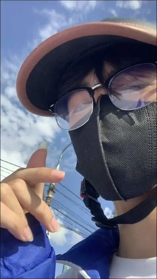 18 Nam sinh đứng trong phòng, dùng điện thoại che mặt và tạo dáng nhẹ, ánh sáng trong nhà giúp bức ảnh rõ nét