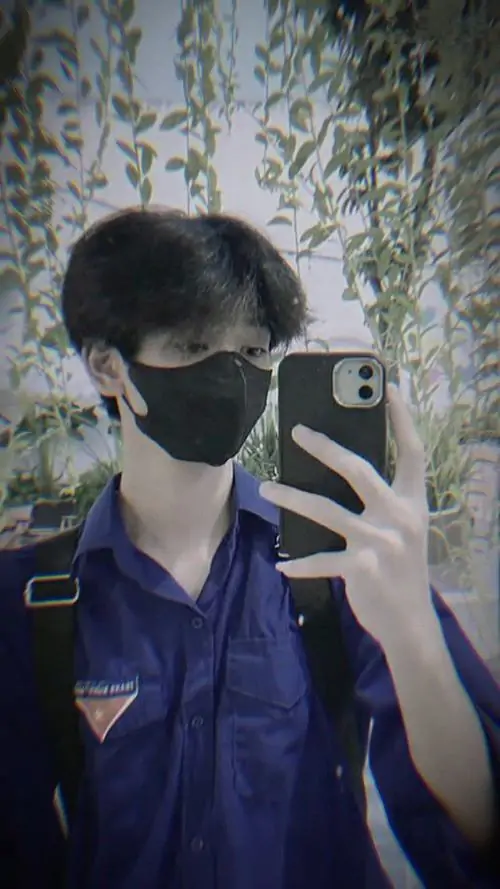 21 Nam sinh đứng ở hành lang trường, quay mặt sang bên để giấu đi biểu cảm, tạo vibe học sinh đời thường