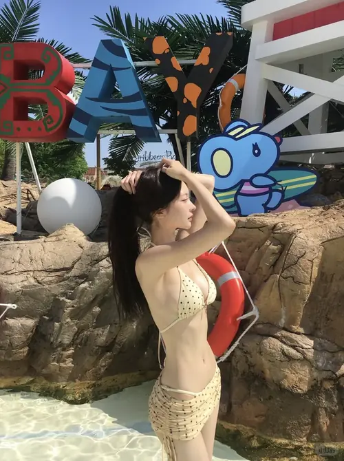8 Dọc bãi cát trắng, cô gái diện bikini cam bước chân trần, mái tóc dài bay về một bên.