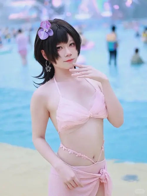 7 Dưới ô che biển, cô gái tóc búi cao cầm ly nước và mỉm cười trong bộ bikini đỏ.