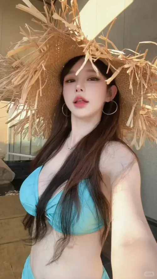 25 Chiếc bikini sọc xanh trắng đi cùng tóc búi thấp, khi cô gái ngồi cạnh chiếc túi đan nhỏ.
