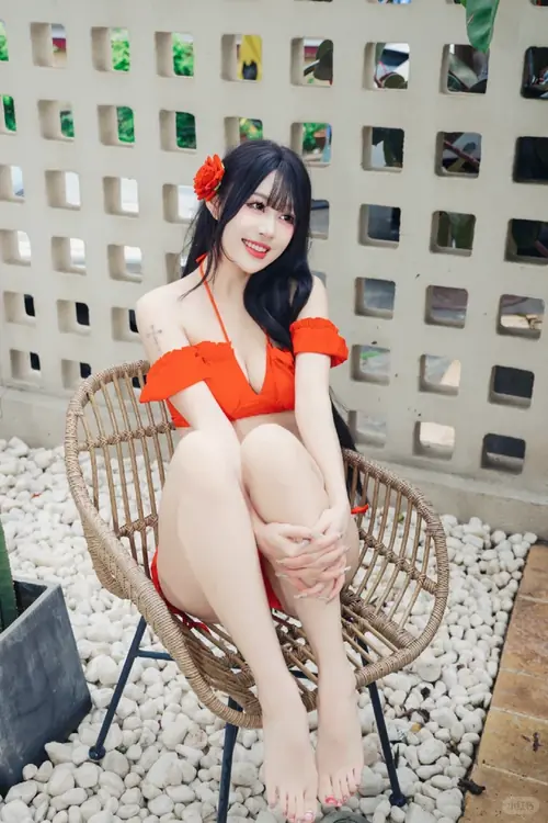 17 Cô gái cầm mũ cói bên hông, mặc trang phục đi biển tối giản và bước chậm trên cát ướt.