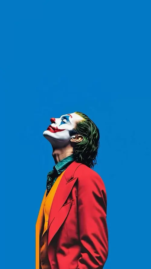 25 Giữa ánh sáng đỏ gắt, hình nền Joker nổi bật với áo dài và cây gậy đen.