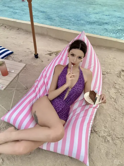 15 Sợi vòng cổ vỏ sò nổi bật trên làn da cô gái mặc bikini xanh, tóc ướt và cười nhẹ.
