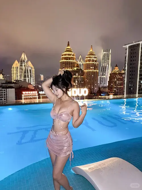 2 Mái tóc dài che nửa gương mặt người mẫu diện bikini trắng, đứng cạnh sóng biển Nha Trang trong veo.