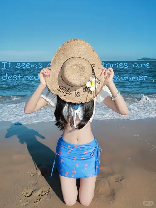 14 Cô gái đội mũ cói rộng vành, ngồi trên cát với bikini vàng và ánh mắt hướng ra biển.
