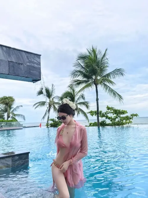 1 Nắng sớm phủ vai người mẫu trưởng thành diện bikini trắng, phía sau là bãi biển Copacabana đông vui.