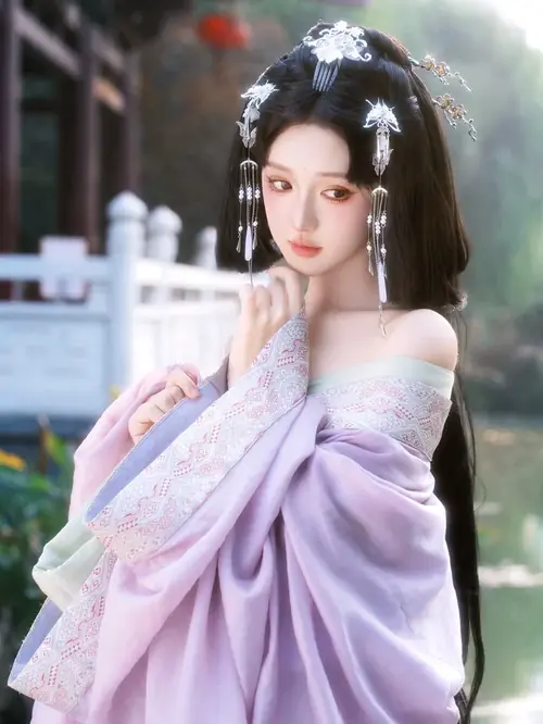 24 Một cánh sen hồng nằm trên tay nhân vật mặc áo lục, gương mặt hơi cúi và môi mỉm nhẹ.