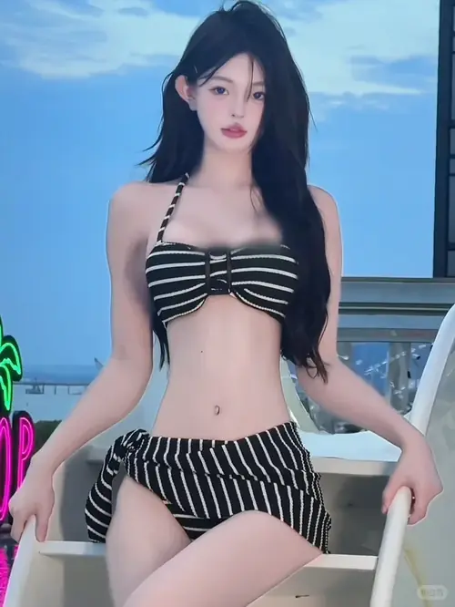 24 Bikini sọc xanh trắng kết hợp túi cói tạo vẻ trẻ trung khi cô gái đi cạnh hàng ghế nghỉ.