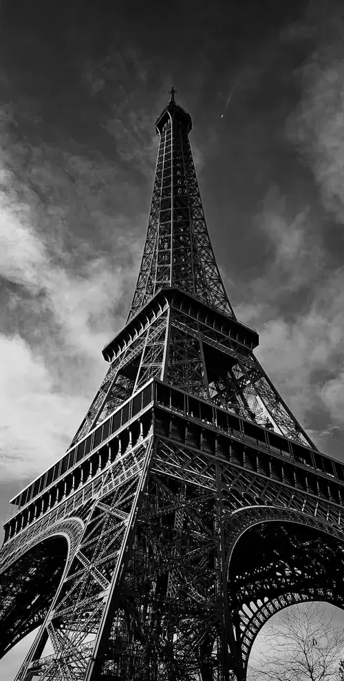4 Tháp Eiffel nhìn từ dưới lên trong hình nền màu xám cho điện thoại với mây tối phía sau.